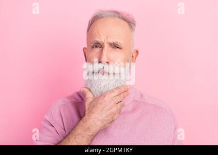Photo of strict grey hair senior man hand chin wear pink sweater isolated on pastel color background Stock Photo