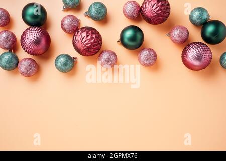 Pink and green Christmas baubles on retro orange background Stock Photo