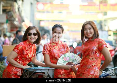 three asian woman wearing chinese tradition suit standing in bangkok china town Stock Photo