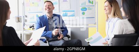 Man businessman in wheelchair conducts business briefing with colleagues Stock Photo