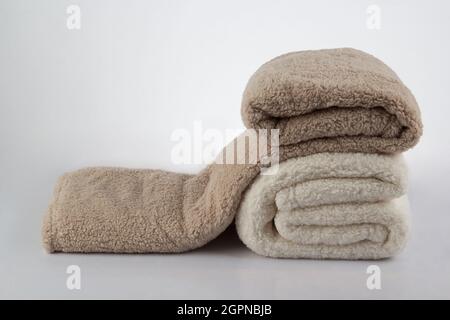 Soft and warm stack of folded blankets isolated on white background Stock Photo