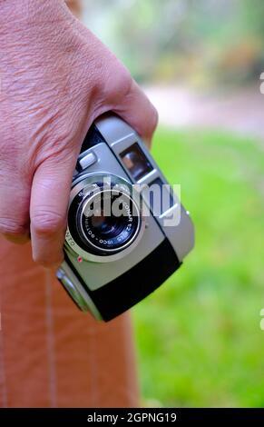 senior female person holding vintage film camera in countryside setting, norfolk, england Stock Photo