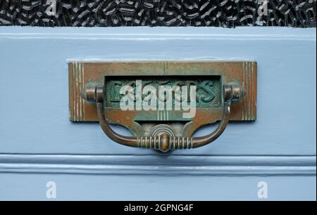 weathered victorian style brass letterbox on blue painted front door, yorkshire, england Stock Photo