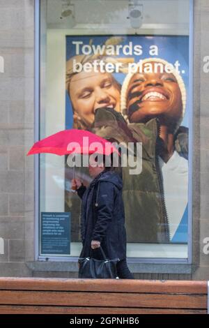 'Towards a better planet' sign in Preston, Lancashire. UK Weather. 02 Oct 2021.  Heavy rain for shoppers in the city centre soon after United Utilities issue a warning to restrict water usage due to the low levels in supply reservoirs to the area. Stock Photo