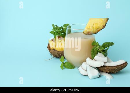 Pina colada cocktail and ingredients on blue background. Stock Photo