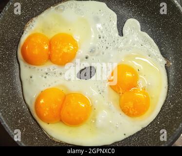 Fried eggs in the frying pan close-up. Top view. Stock Photo