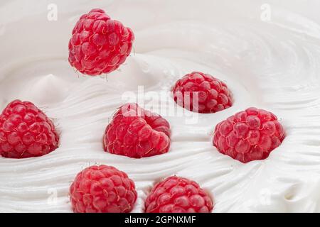 Fresh raspberries in the yoghurt or cream. Top view. Stock Photo