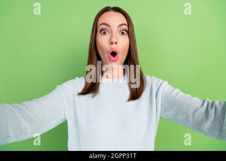 Photo of impressed young brunette lady do selfie wear blue jumper isolated on green color background Stock Photo