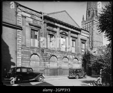 County Hall, Cuckoo Lane, Coventry, 1941. County Hall viewed from Cuckoo Lane with the tower of Holy Trinity Church in the background. The former courthouse at County Hall opened in 1783. In 1988 the courts moved to new premises in Much Park Street and the building lay empty until it was converted for use as a bar in 2000. It is now known as The Establishment.  In this photograph the windows of County Hall are boarded, probably as a result of the air raids in November 1940 which left the adjacent cathedral in ruins and destroyed much of the historic fabric of the city. Stock Photo