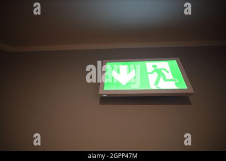 Emergency exit sign on the office wall Stock Photo