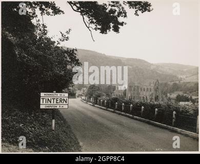 Tintern Abbey, Monmouthshire, Wales, 1951. A view looking north-west towards Tintern Abbey, with a road sign displaying 'Tintern' in the foreground. Tintern Abbey was founded in 1131, and was dissolved in 1536. It was the first Cistercian house to be founded in Wales, and the second in Britain. Stock Photo