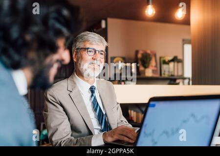 Italy, Businessmen using laptops in creative studio Stock Photo