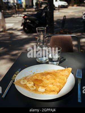 France, Paris, Crepes with banana slices on plate outdoors Stock Photo