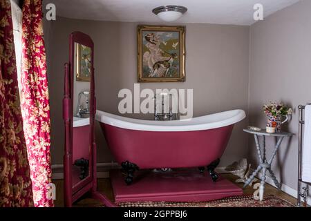 https://l450v.alamy.com/450v/2gppbj6/bold-pink-bath-with-vintage-curtains-and-needlework-panel-in-suffolk-cottage-2gppbj6.jpg