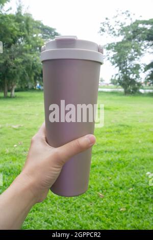 Hand on coffee stainles steel thermo cup, stock photo Stock Photo