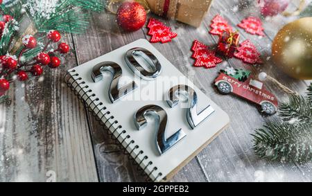 Watermark Christmas 2022 Numbers 2022 On A Spiral Notepad On A Wooden Background With Christmas  Decorations Stock Photo - Alamy
