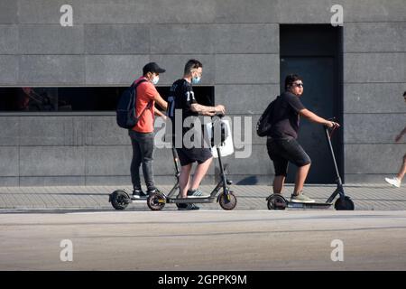 Group of men with their electric scooter are waiting in a street. Stock Photo