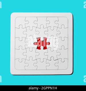 a red gap in a blank white jigsaw puzzle missing a piece on a blue background Stock Photo