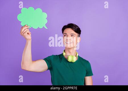 Photo of dreamy minded positive young man hold cloud speech headphones isolated on violet color background Stock Photo