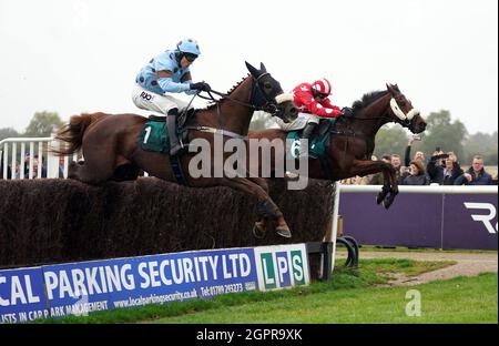 Fat Sam ridden by jockey James Davies (left) clear a fence on their way to winning the Colliers Saves Business Rates Handicap Chase at Warwick Racecourse. Picture date: Thursday September 30, 2021. Stock Photo