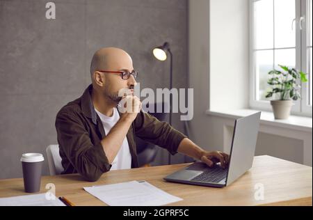 Young Caucasian man work online on computer at home Stock Photo