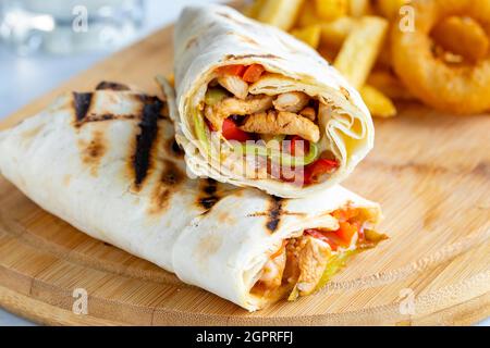 Chicken wrap on a white background. With french fries and onion rings Stock Photo