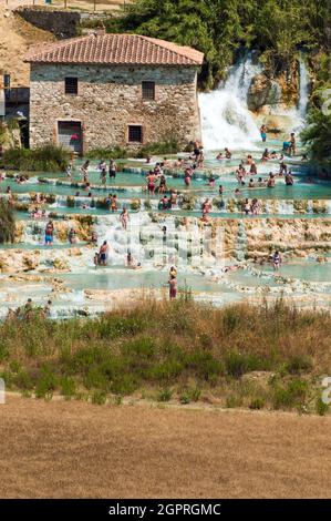 Saturnia, Grosseto, Italy, july 2021. Large group of people bathing in the natural thermal waters in Saturnia thermal waterfalls Stock Photo