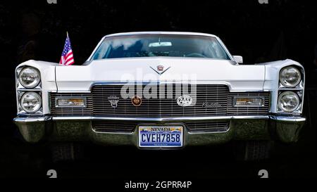 Classic Cadillac DeVille, white, with a Nevada plate, front view against a black background. Stock Photo
