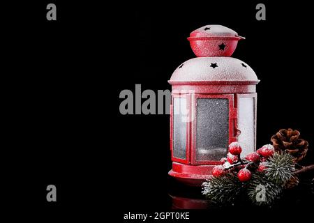 Christmas Red Lantern On Snow With Fir Branch on Black Background. Winter Decoration Background Stock Photo