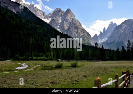 Rural setting in the presence of the mountains at the entrance to the Val Fiscalina Stock Photo