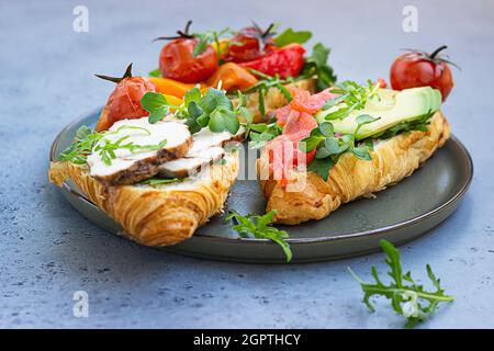 Croissant Sandwiches With Vegetables, Smoked Salmon, Turkey, Avocado And Arugula With Microgreen.