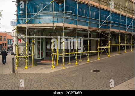 Scaffolding on a large building in Norwich City with warning tape on lower scaffolding Stock Photo