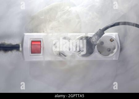 Failure caused by burning of the wire cable and socket outlet plug in the house, blurred photo, concept blurred background, selective focus. Stock Photo