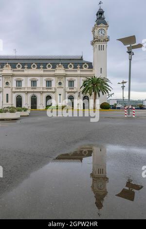 The Edificio del Reloj clock tower, port of Valencia, Spain, is reflected in a puddle of water Stock Photo
