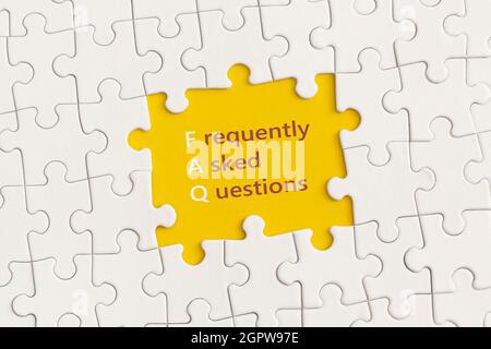 White details of puzzle with the text FAQ on yellow background. Stock Photo