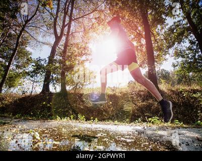 Jogging Tall Sports Man In Trees Shadows While Wearing Black Yellow Shorts And Blue Jogging Attire