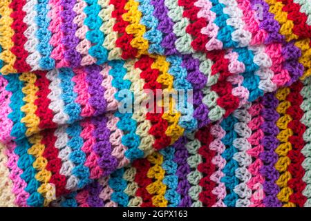 knitted wool fabric abstract, colorful woven yarn background texture, folded textile backdrop or wallpaper closeup Stock Photo