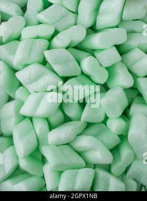 styrofoam packaging chips or peanuts, closeup of light weight green packing and cushioning material background texture Stock Photo