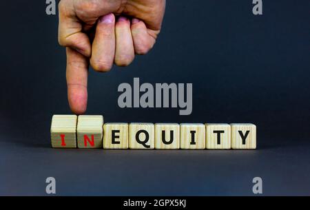 Inequity or equity symbol. Businessman turns wooden cubes and changes the word inequity to equity. Business and inequity or equity concept. Beautiful Stock Photo