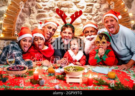 Funny selfie pic of multi generation large family with santa hats having fun at Christmas fest house party - Winter holiday xmas concept Stock Photo