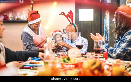 Large multi generation family having fun at christmas supper party - Winter holiday x mas concept with parents and children eating together Stock Photo