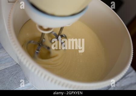 Step by step the process of making sour cream pie dough. The ingredients are added to the mixer bowl. The dough is kneaded with a whisk. Baking concep Stock Photo