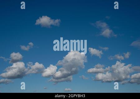 fluffy white clouds against a blue sky. Stock Photo