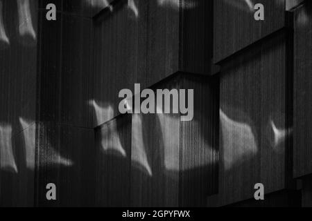 Closeup of abstract reflections on exterior of stone building Stock Photo
