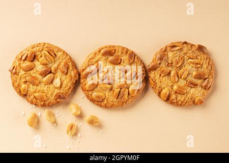 Cookies with roasted peanuts on top on beige background. View from above. Place for text. Stock Photo