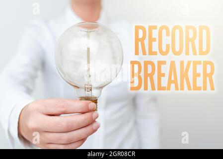 Hand writing sign Record Breaker, Word for someone or something that beats previous best result Lady in business outfit holding lamp presenting new te Stock Photo