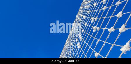 Volleyball net covered with snow. Nature's minimalism.  Stock Photo