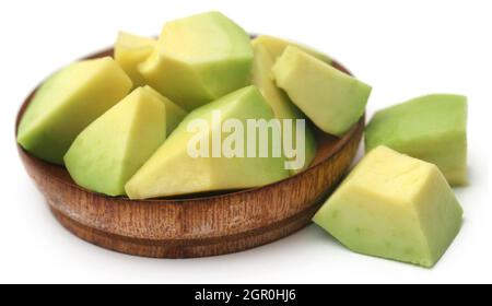 Fresh sliced avocado in a wooden bowl over white background Stock Photo