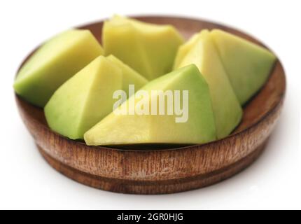 Fresh sliced avocado in a wooden bowl over white background Stock Photo
