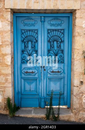 Blue wooden door with vertical letterbox and door knocker, house number ...
